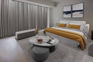 Ottawa apartment for rent - A modern bedroom with a large bed and a grey sofa.