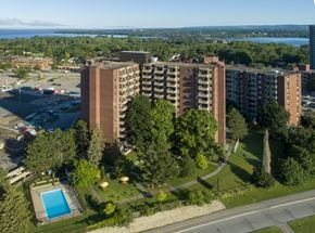 Ottawa apartment for rent - A large apartment complex with a pool and a parking lot.