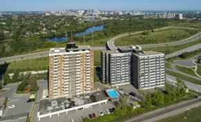 Ottawa apartment for rent - Two large buildings are situated next to a pool and a road.