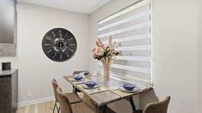 Edmonton apartment for rent - A dining room with a table set for two and a clock on the wall.