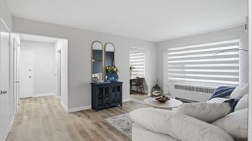 Edmonton apartment for rent - A living room with a white couch and a wooden cabinet.