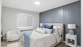 Edmonton apartment for rent - A bedroom with a white bed and a white chair.