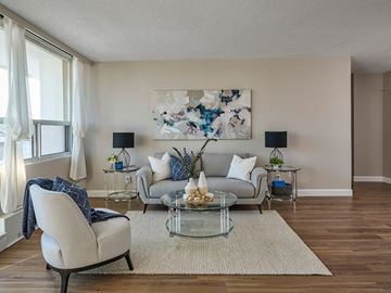 Ottawa apartment for rent - A living room with a grey couch, a glass table, and a painting on the wall.