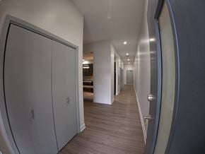 Indianapolis apartment for rent - A long hallway with a white door on the left and a grey door on the right.