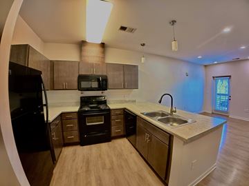 Indianapolis apartment for rent - A kitchen with a black refrigerator and a black microwave.