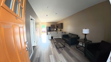Indianapolis apartment for rent - A living room with a black couch and a wooden floor.