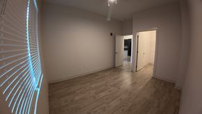 Indianapolis apartment for rent - A room with a wooden floor and a white wall with a doorway leading to another room.