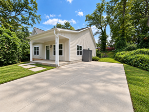 Greenville house for rent - A small white house with a porch and a driveway in front.