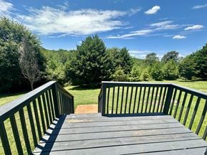 Anderson apartment for rent - A wooden deck with railings overlooks a grassy area with trees.