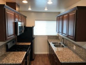Los Angeles apartment for rent - A kitchen with granite countertops and dark wood cabinets.