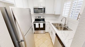 Los Angeles townhouse for rent - A kitchen with a refrigerator, microwave, oven, and sink.
