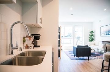 Los Angeles apartment for rent - A modern kitchen with a stainless steel sink and a black chair in the living room.
