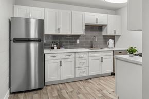 Phoenix apartment for rent - A modern kitchen with a stainless steel refrigerator and white cabinets.