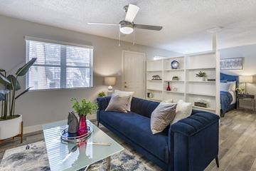 Phoenix apartment for rent - a living room with a blue couch and a glass coffee table