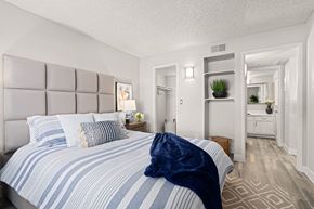 Tucson apartment for rent - a bedroom with a large bed and a bathroom in the background