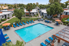 Mesa apartment for rent - A swimming pool surrounded by blue lounge chairs and umbrellas.
