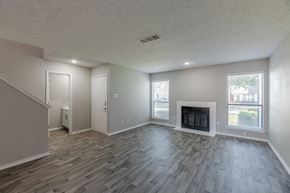 Euless townhouse for rent - A living room with a fireplace and wood flooring.