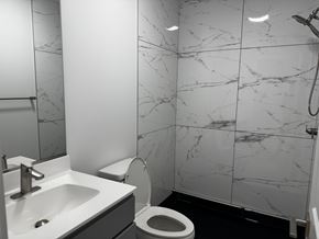 Baltimore apartment for rent - A bathroom with a sink, toilet, and marble tiles.