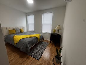 Baltimore apartment for rent - A bedroom with a bed, nightstand, and window.