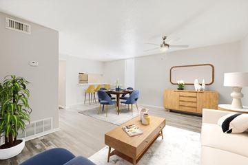 Castle Hills apartment for rent - A living room with a blue couch, a wooden coffee table, and a dining table with chairs.