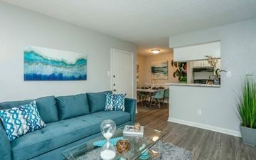 Pasadena apartment for rent - A living room with a blue couch and a painting on the wall.