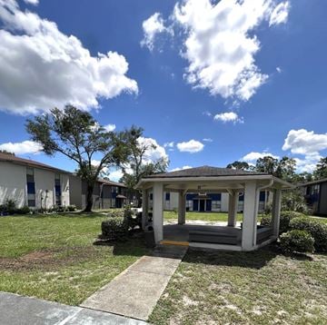 Jacksonville apartment for rent - A gazebo is in the middle of a grassy area with apartment buildings in the background.