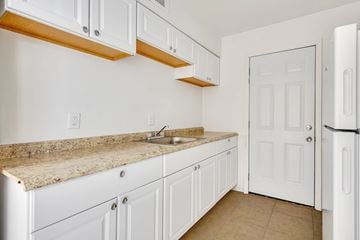 Jacksonville apartment for rent - A kitchen with white cabinets and a granite countertop.