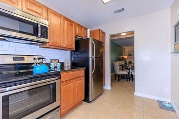 Gainesville apartment for rent - A kitchen with a black refrigerator and stove top oven.