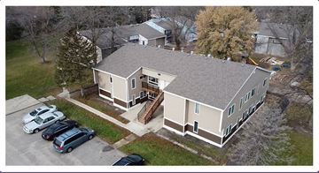 Willmar apartment for rent - A house with a grey roof and a parking lot in front.