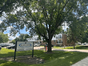 Willmar apartment for rent - A tree stands in front of a Suite Living apartment complex.