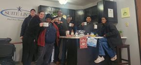 Marshall apartment for rent - A group of people are gathered around a table in a room with a sign that says "Suite Living" on the wall.