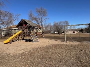 Willmar apartment for rent - A playground with a yellow slide and a wooden structure.