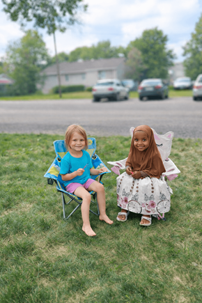 Willmar apartment for rent - Two children sitting on chairs on the grass.