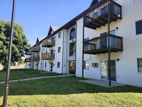 Marshall apartment for rent - A white building with balconies and a green lawn in front.