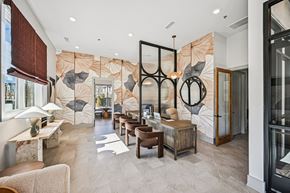 Canton townhouse for rent - A modern living room with a large leaf-patterned wallpaper and a mix of wooden and glass furniture.