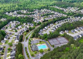 Dallas apartment for rent - A bird's eye view of a residential area with houses, roads, and a swimming pool.