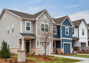 Covington townhouse for rent - A house with a grey and blue exterior and a tree in front.