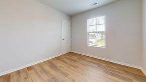 Leland apartment for rent - A room with wooden flooring and a window showing a building outside.