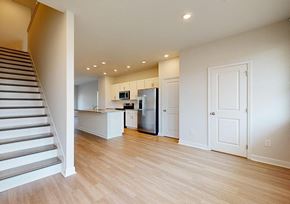 Decatur townhouse for rent - A kitchen with a refrigerator, microwave, and oven is visible from the staircase.