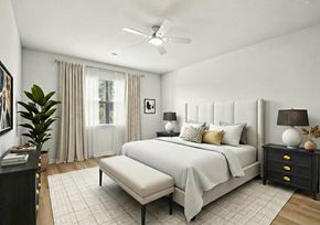 Parrish triplex for rent - A bedroom with a large bed, a bench, and a ceiling fan.