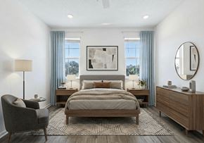 St. Cloud townhouse for rent - A well-lit bedroom with a large bed, a chair, and a painting on the wall.