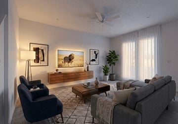 St. Cloud townhouse for rent - A living room with a grey couch, a blue armchair, a wooden coffee table, and a painting on the wall.
