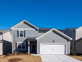 Commerce apartment for rent - A house with a grey facade and a white garage door.