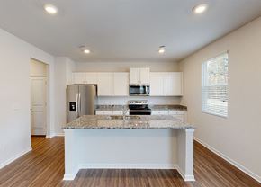 Commerce apartment for rent - A kitchen with a granite countertop and white cabinets.