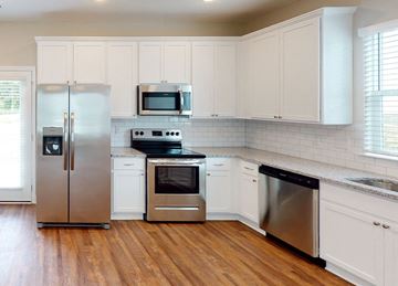 Chattanooga townhouse for rent - A kitchen with white cabinets and a stainless steel refrigerator.