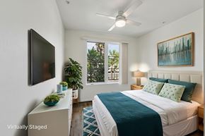Los Angeles apartment for rent - A bedroom with a bed, a television, a plant, and a painting on the wall.