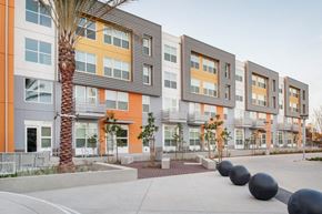 San Diego apartment for rent - an exterior view of an apartment building with a sidewalk and trees