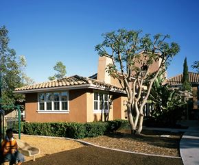 Irvine apartment for rent - a man sitting in front of a house with a tree