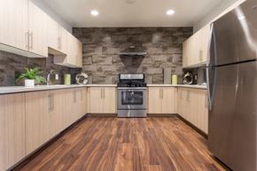 San Diego apartment for rent - a kitchen with white cabinets and stainless steel appliances and wood floors
