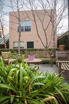 Brisbane apartment for rent - a patio with benches and a table in front of a building